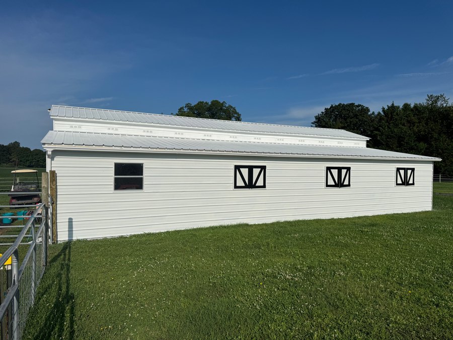 White barn exterior with black window accents and white trim